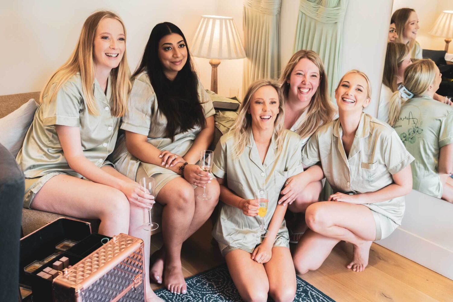 group shot of bridesmaids all laughing looking at someone else's camera