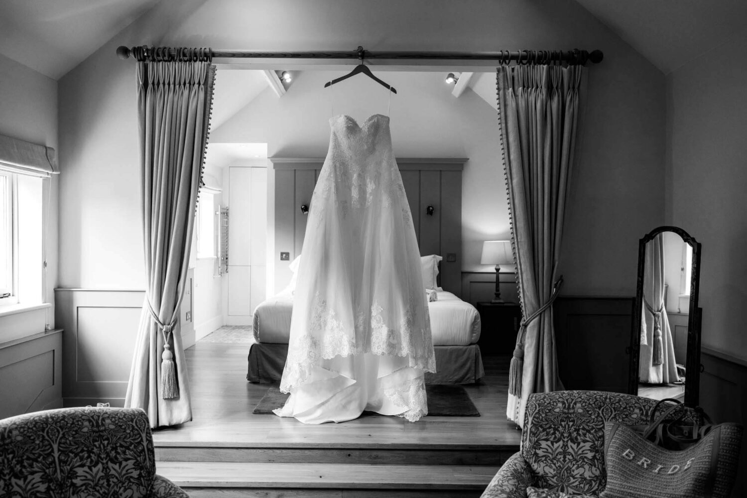 wedding gown hanging from curtain rail in bridal suite