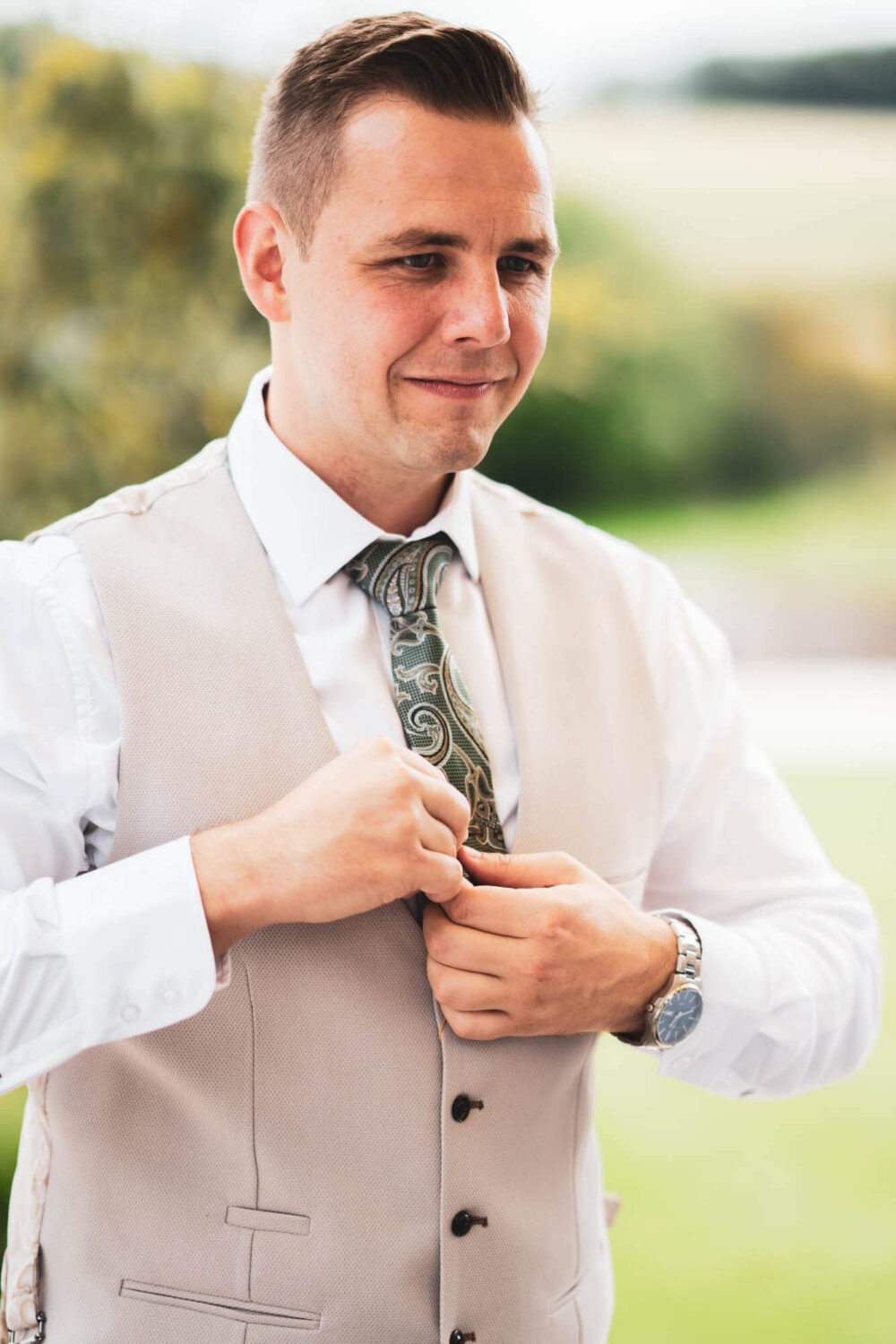 groom tucking in his tie to his jacket