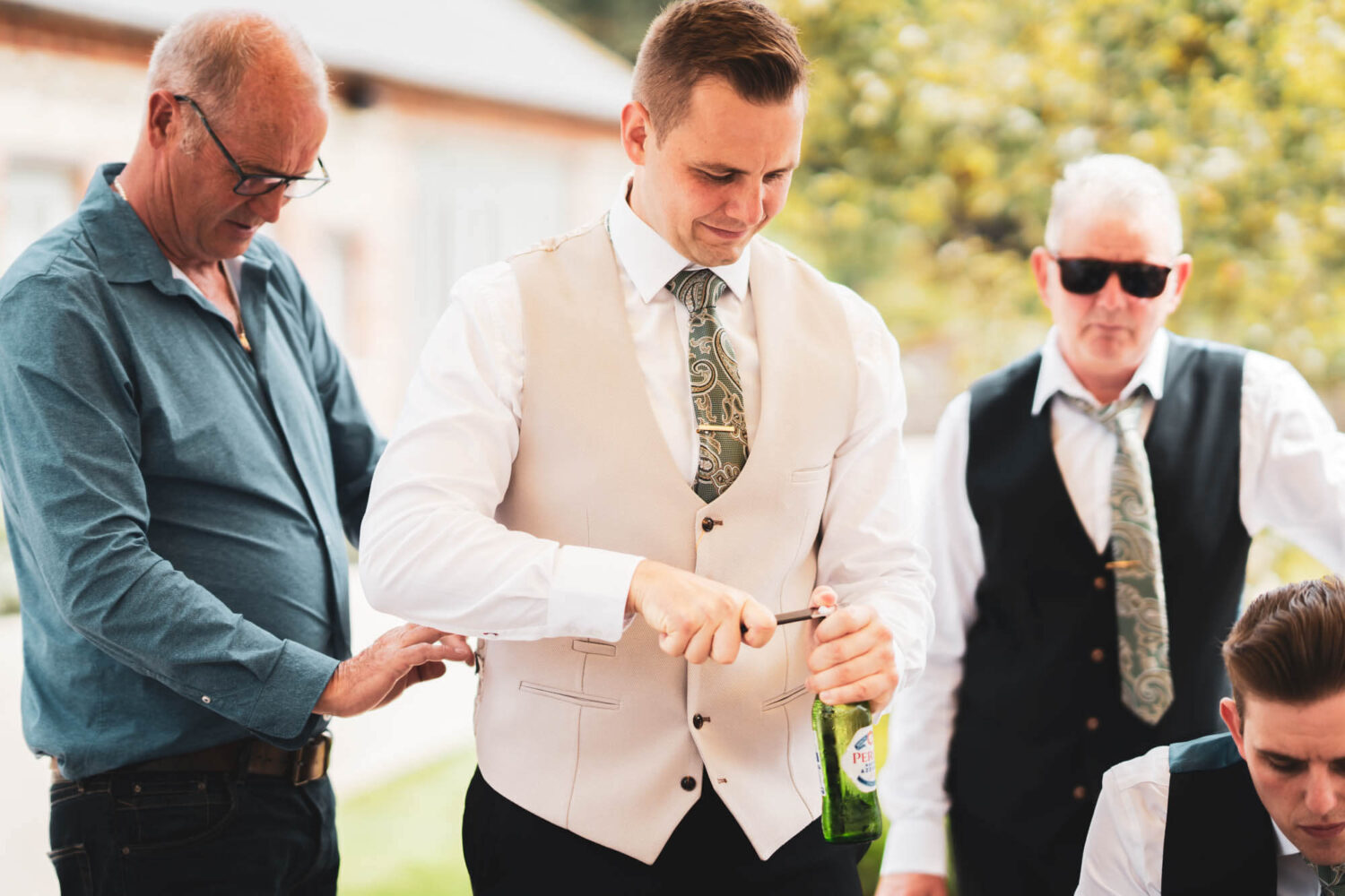 groom opening bottle of beer