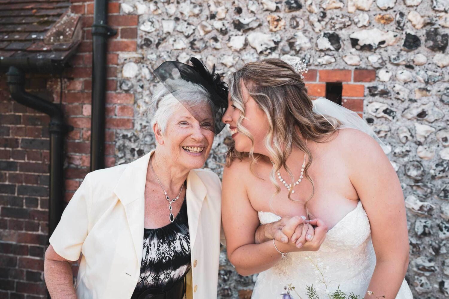 grandma and bride clutching hands smiling