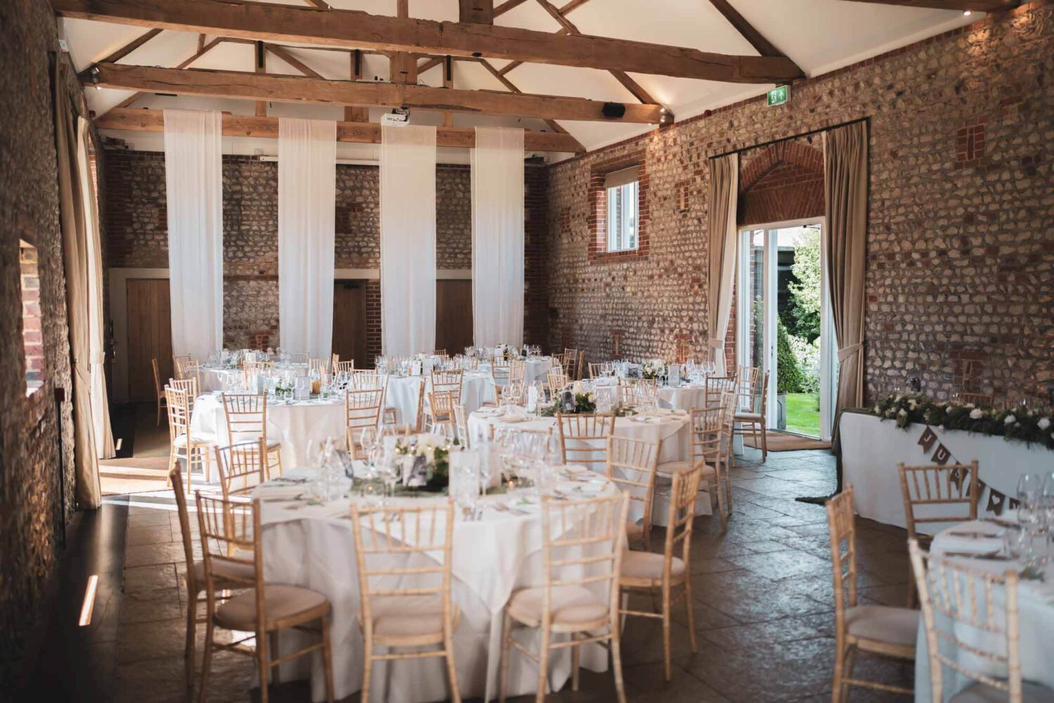 inside of farbridge barn with tables set up for a wedding