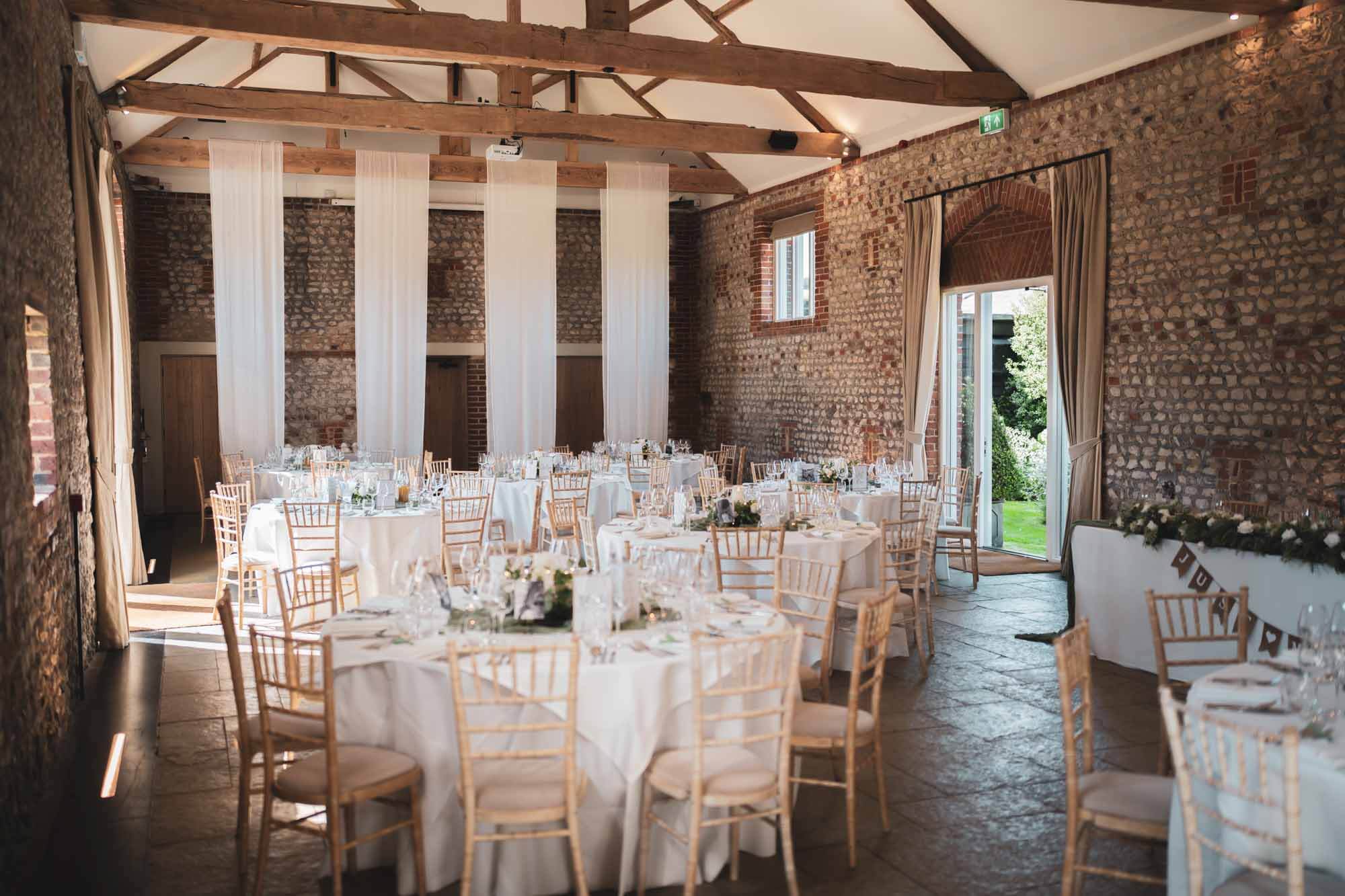 inside of farbridge barn with tables set up for a wedding