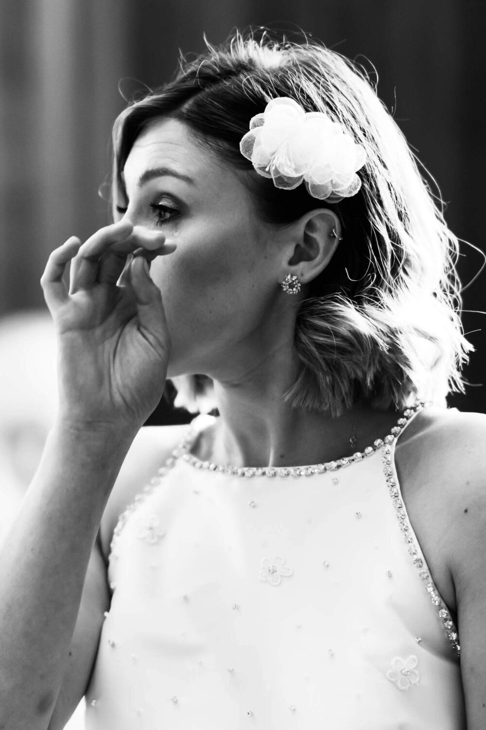 bride wipes away a small tear falling down her cheek