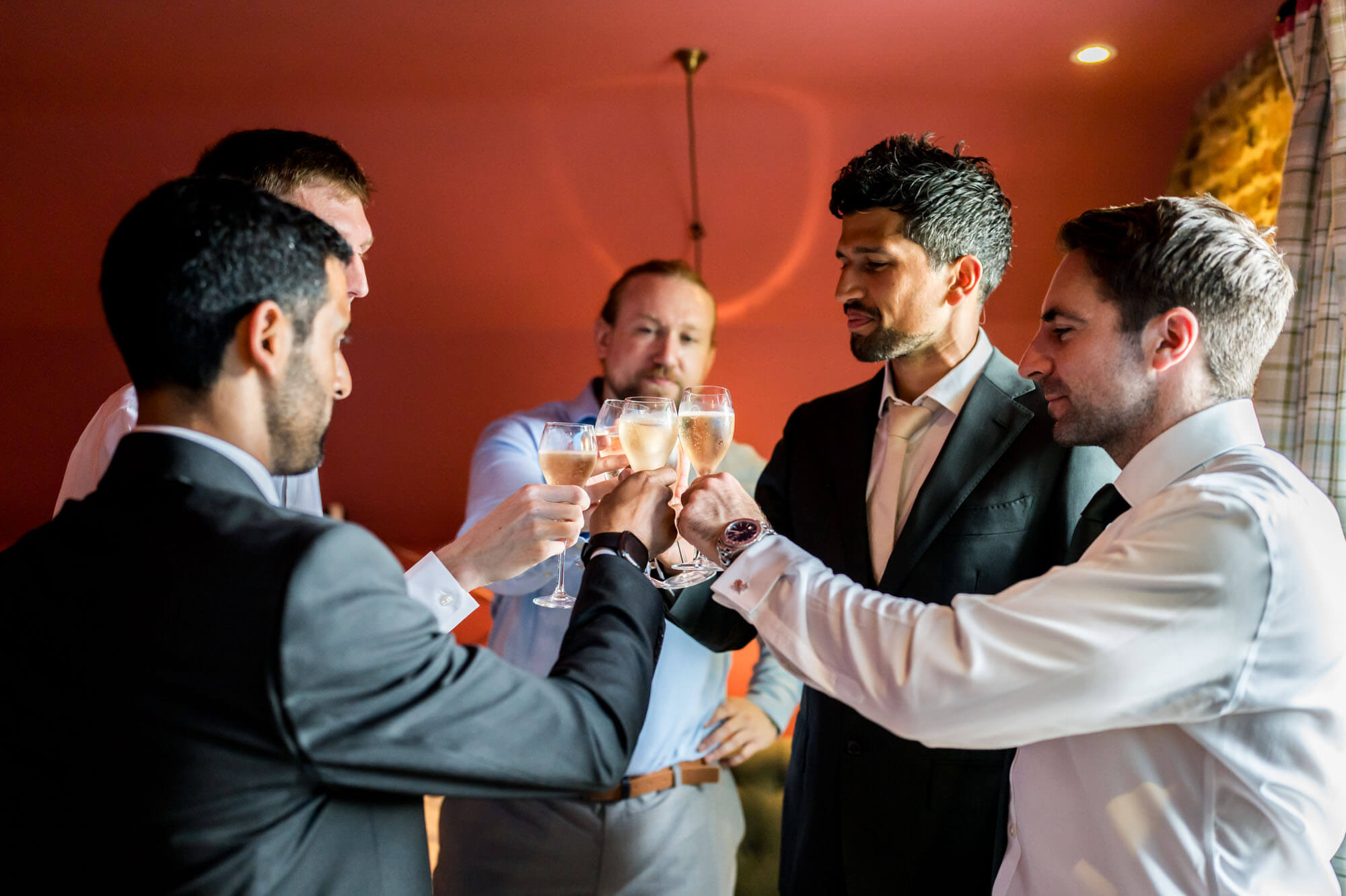 groom and his party chinking glasses