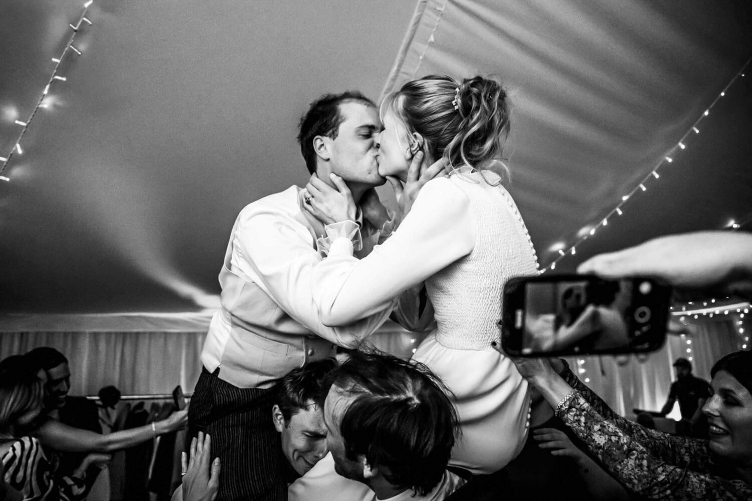 hampshire garden wedding couple kissing on friends shoulders
