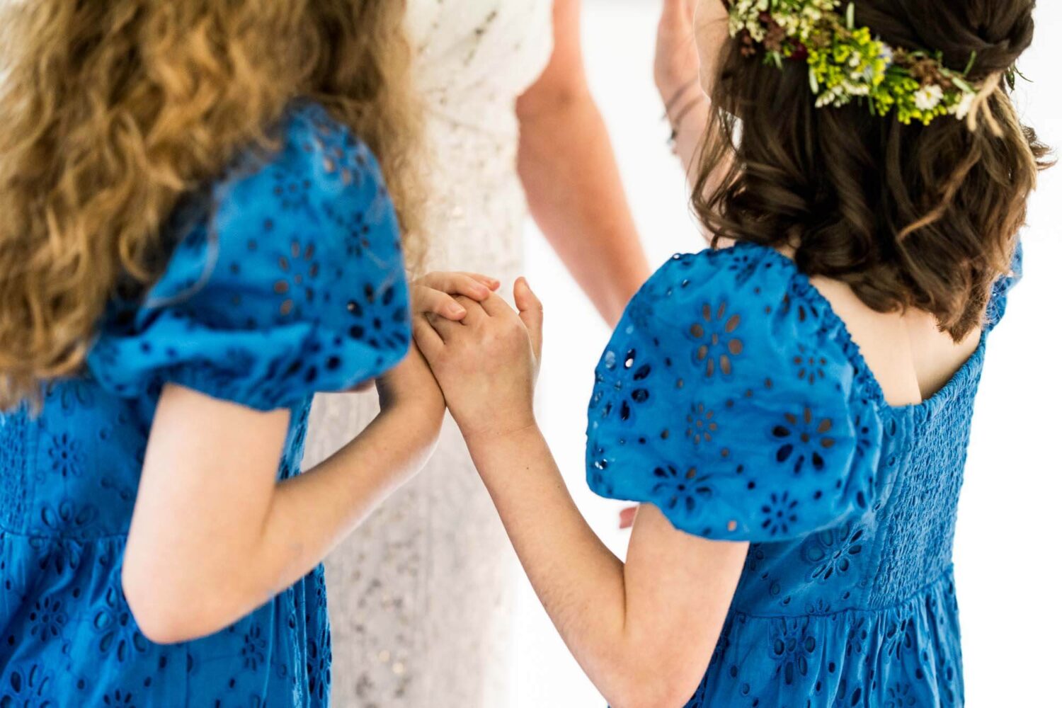 close up of daughters holding hands