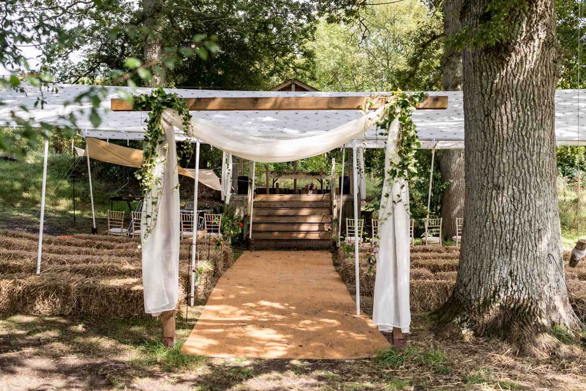 wedding set up with hay bales and wooden arch