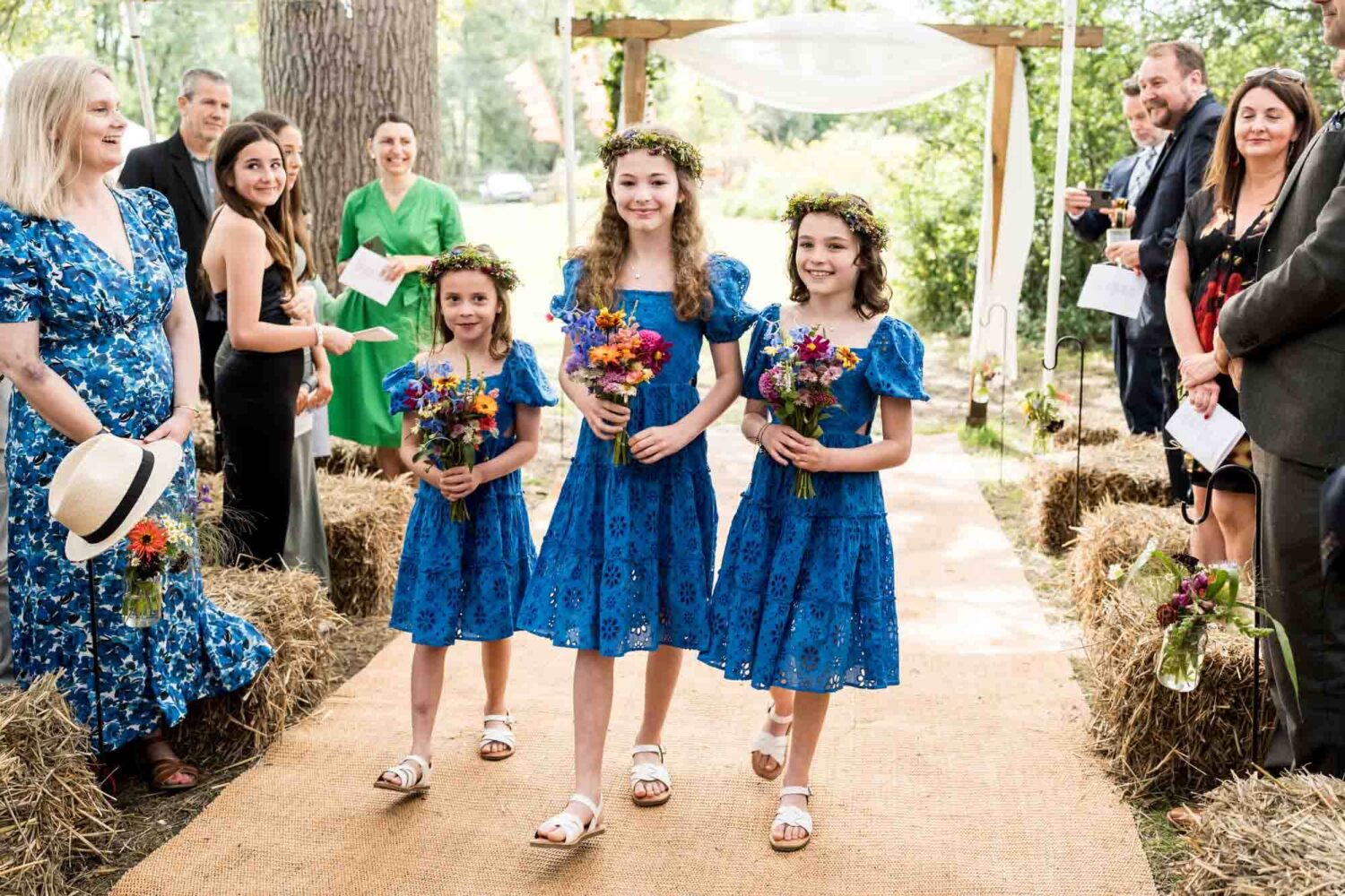 bridesmaids walking up aisle for outdoor ceremony