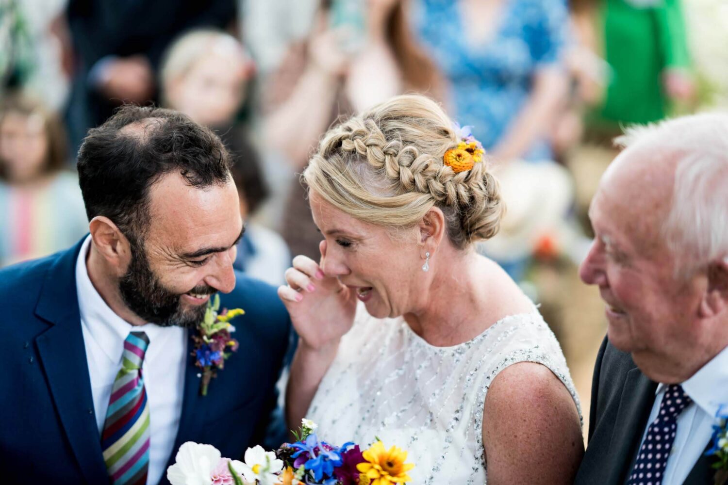 bride wiping away a tear after seeing groom