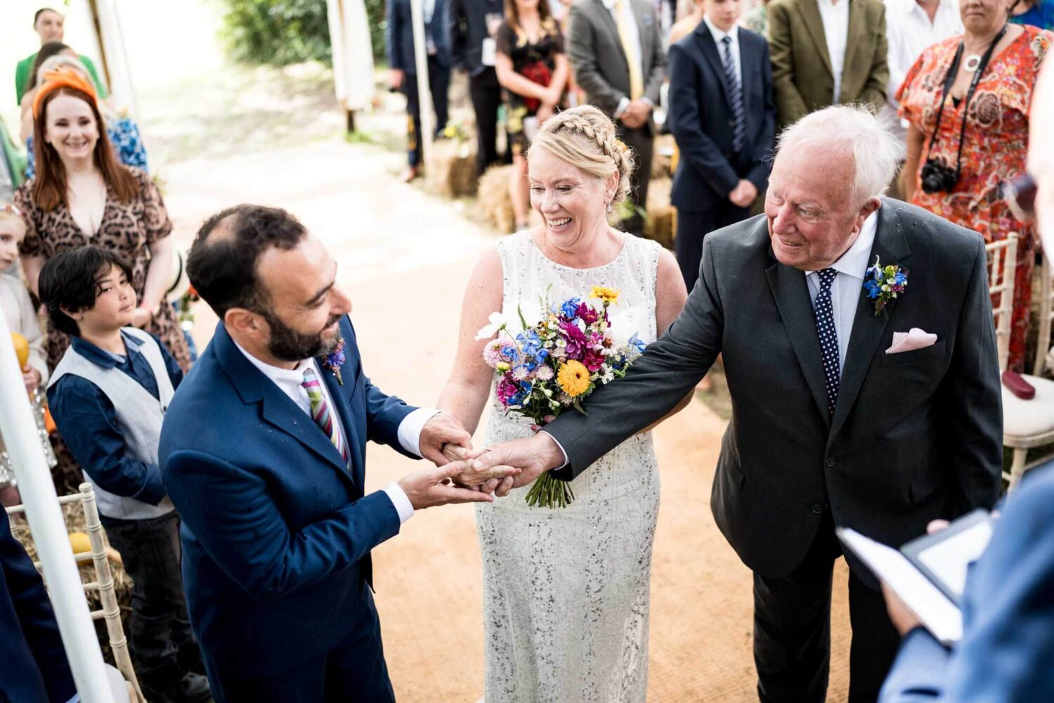 father handing over daughter's hand to groom