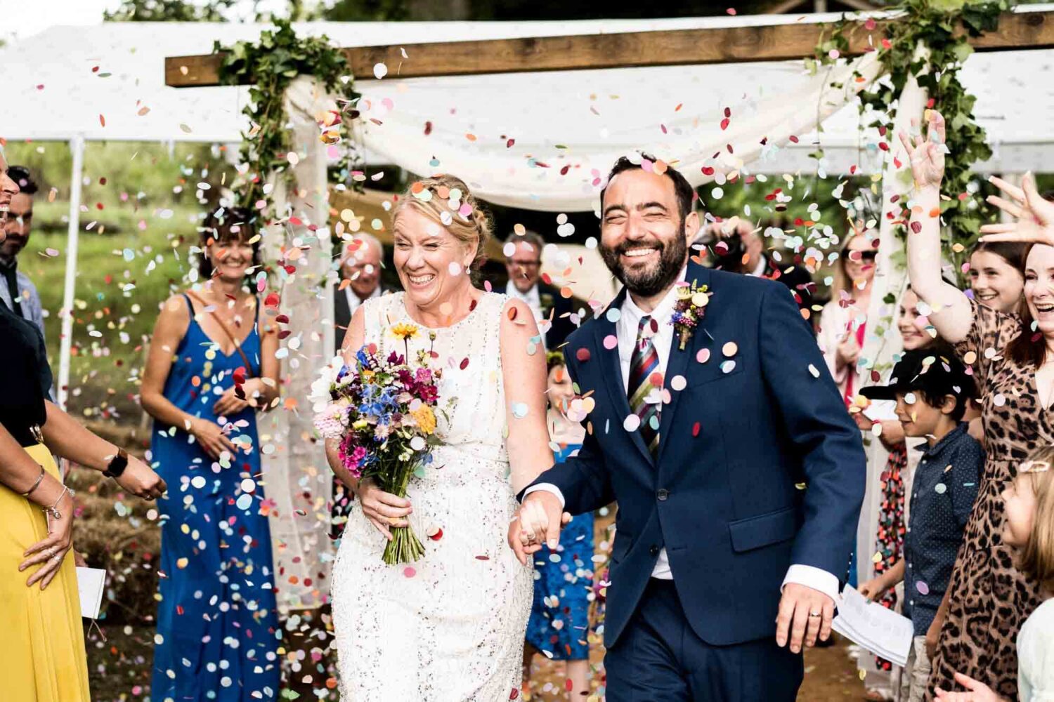 bride and groom walking through amazing confetti