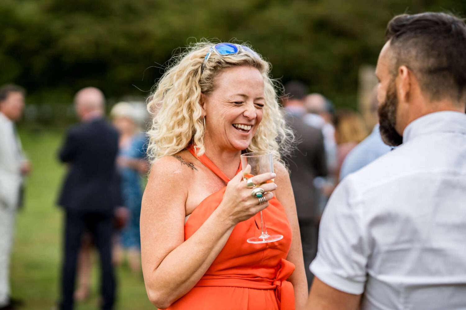 guest laughing holding a drink