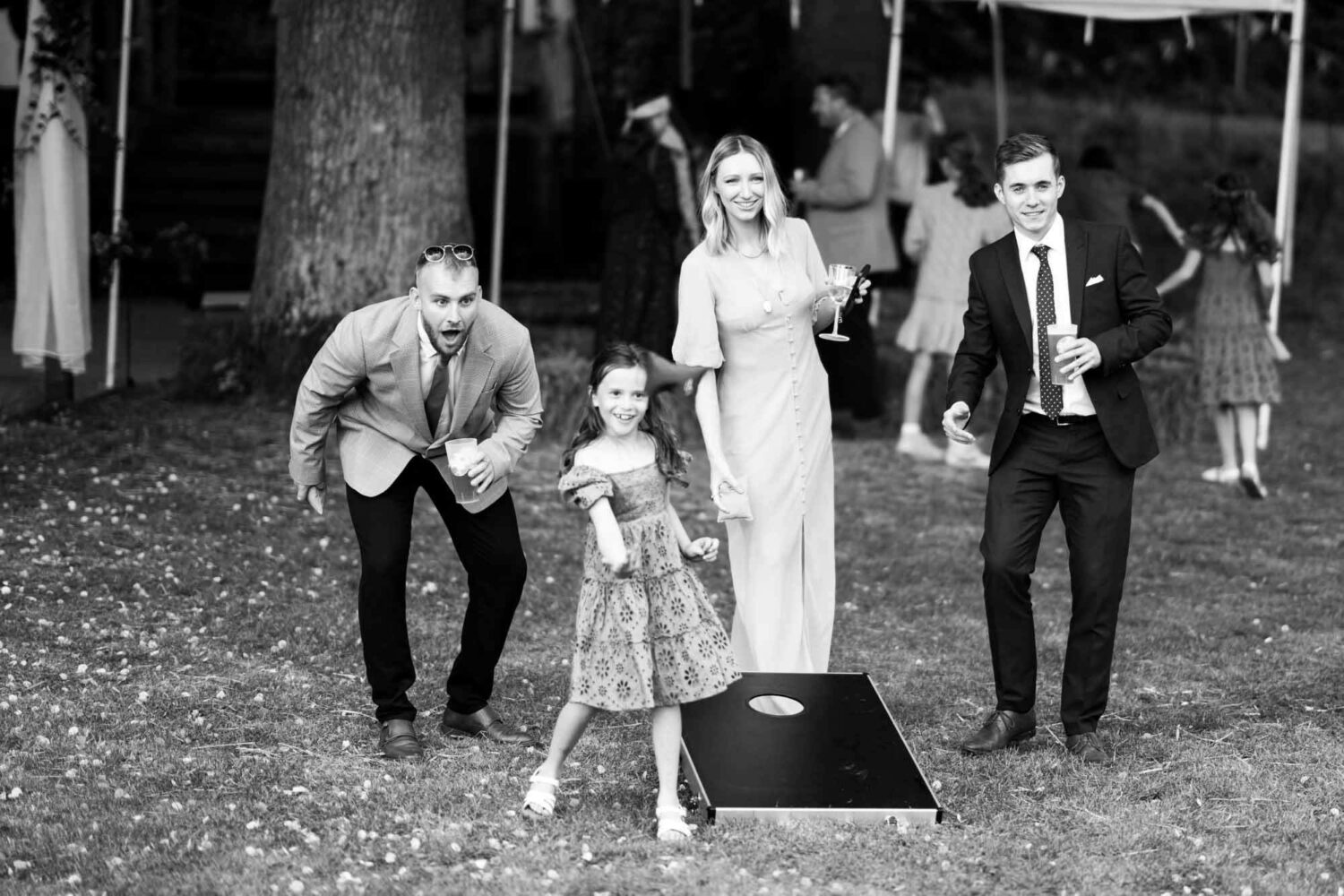 group of guests playing game in field at wedding