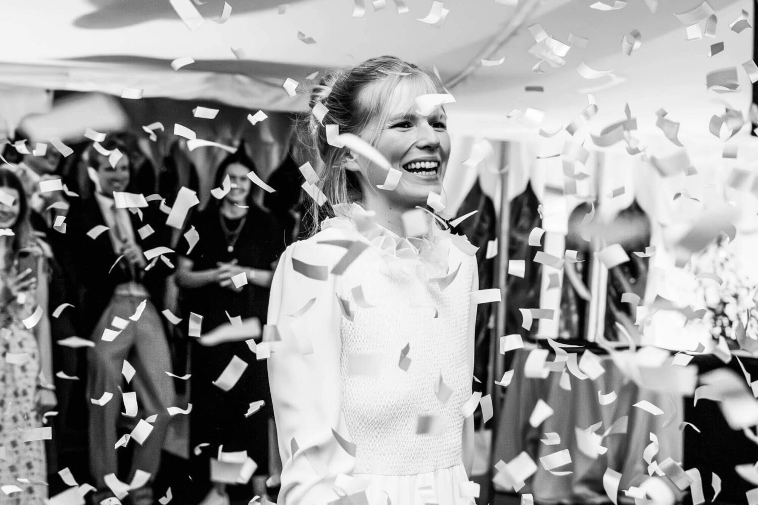bride smiling on dance floor surrounded by confetti canon