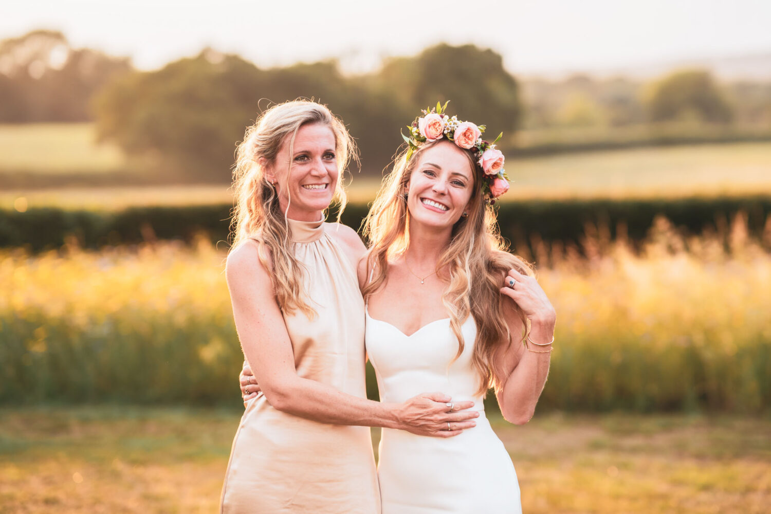 bride and her sister smiling during golden hour