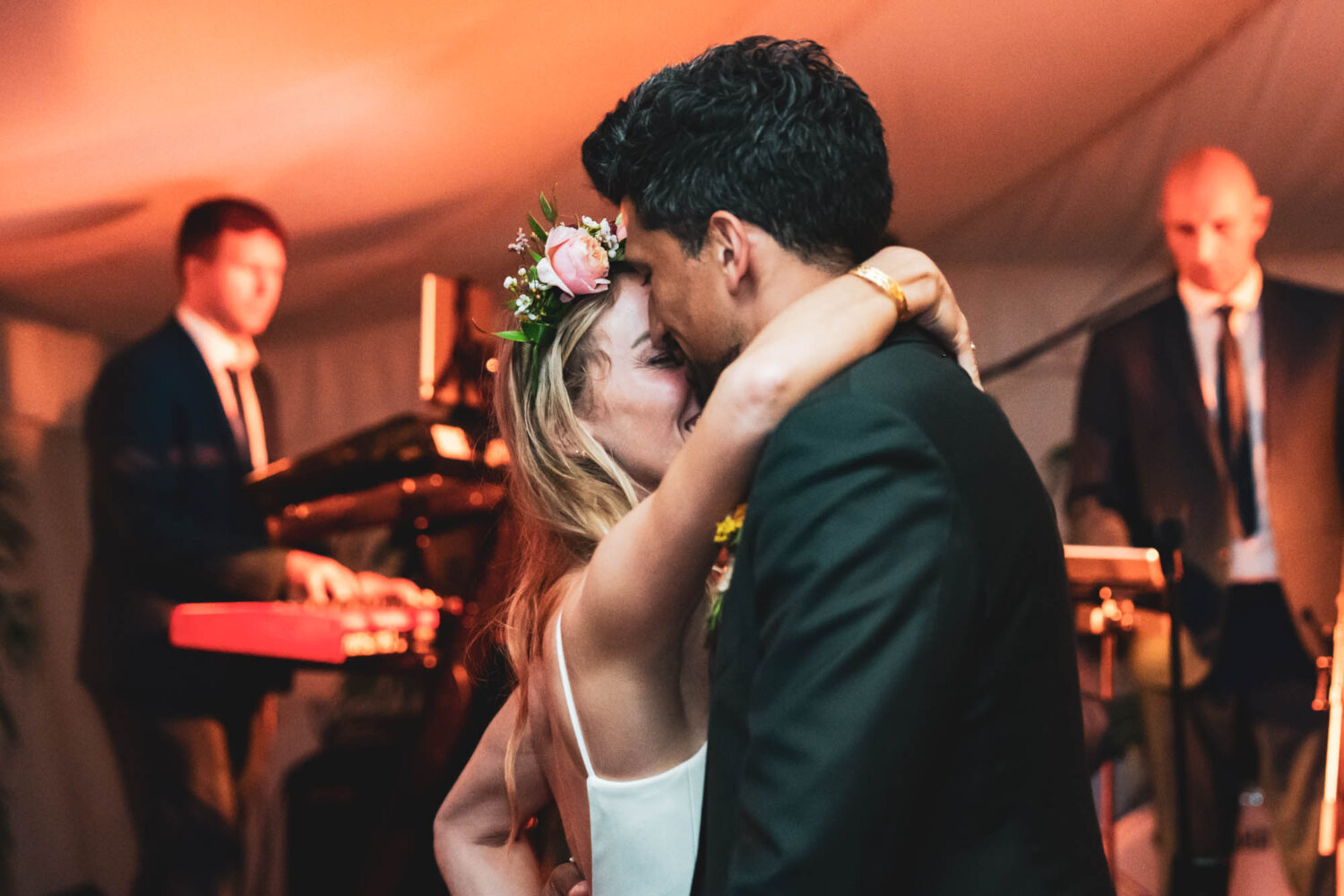 bride with arm wrapped around groom during first dance
