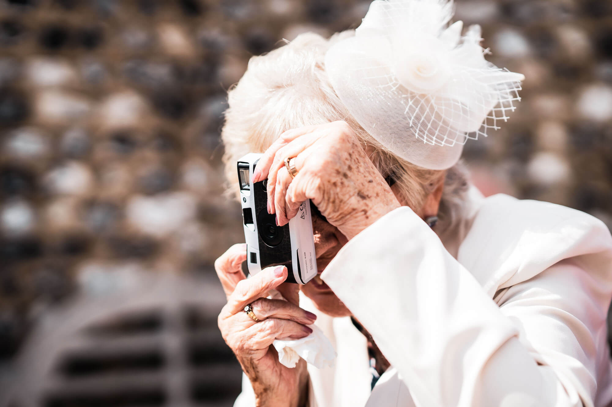 old granny holding a disposable camera taking a shot