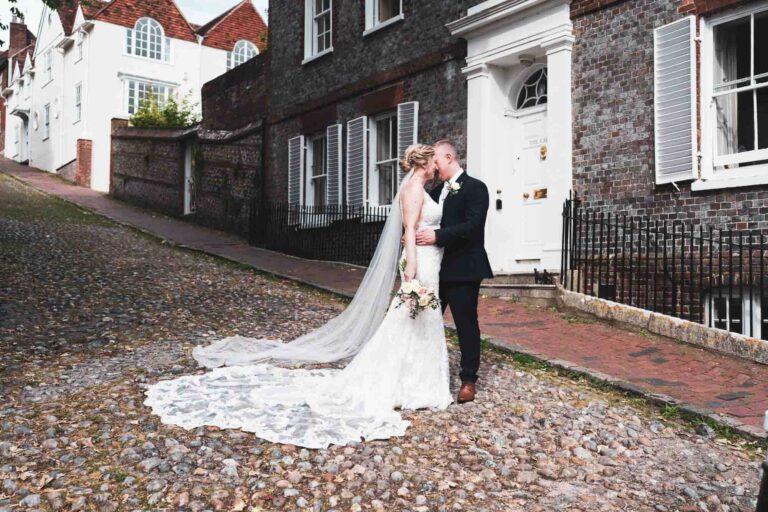 bride and groom holding each other looking into each other on cobbled street in lewes