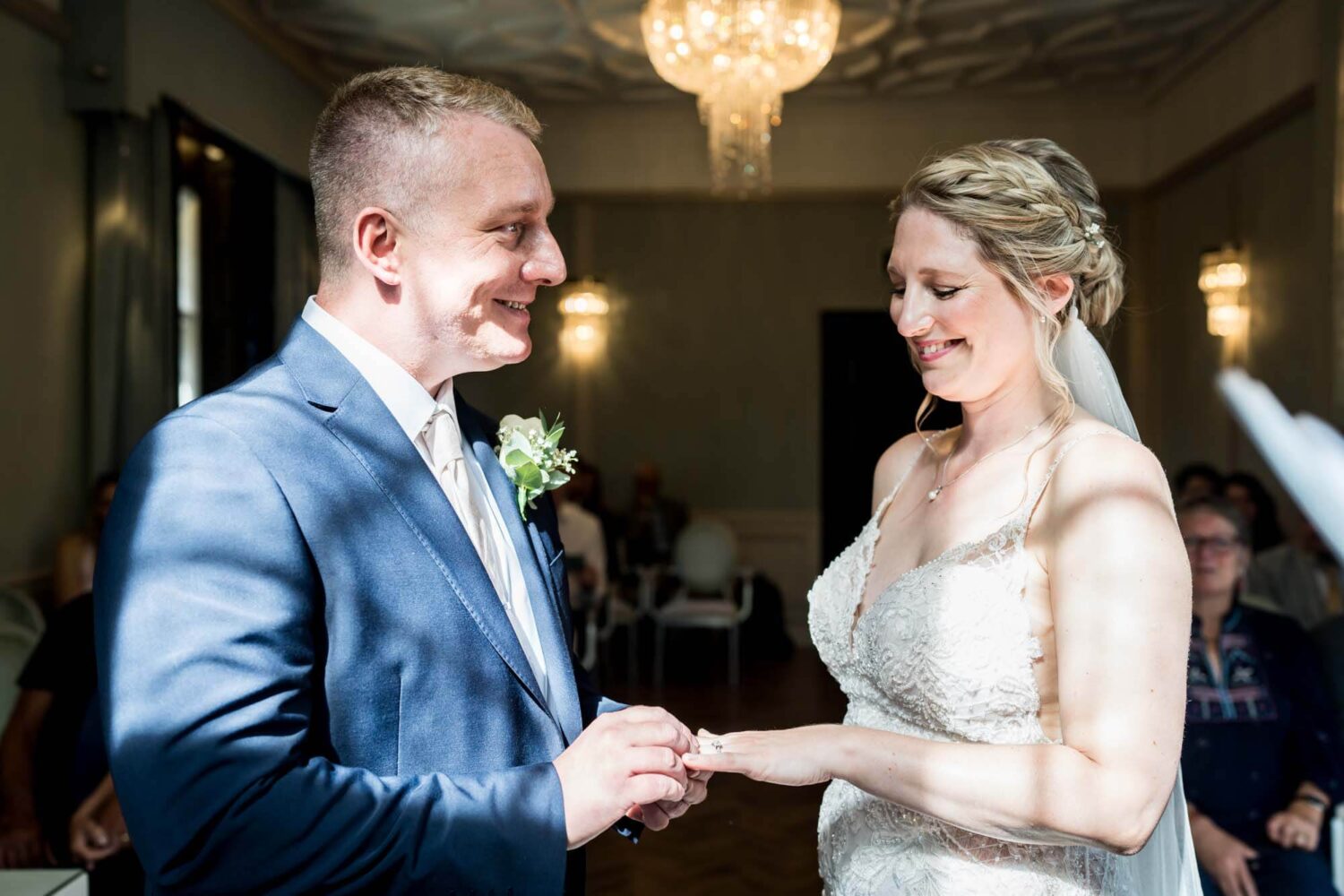 groom putting ring on bride's finger