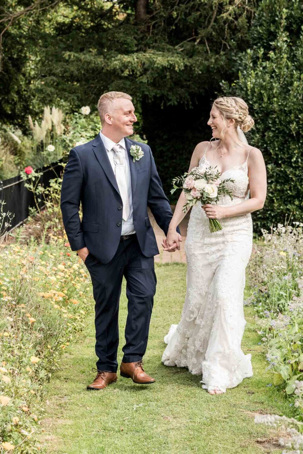 bride and groom walking through Southover grange gardens
