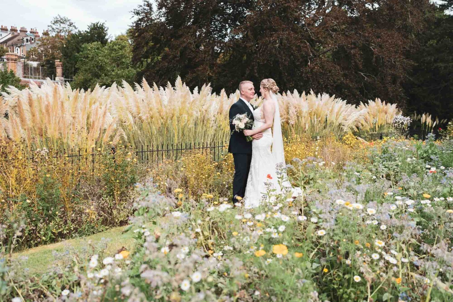 bride and groom standing in stunning Southover grange gardens