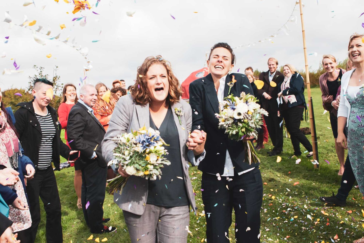 two women just married walking through a shower of confetti