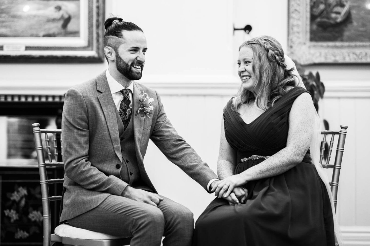bride and groom sitting down holding hands