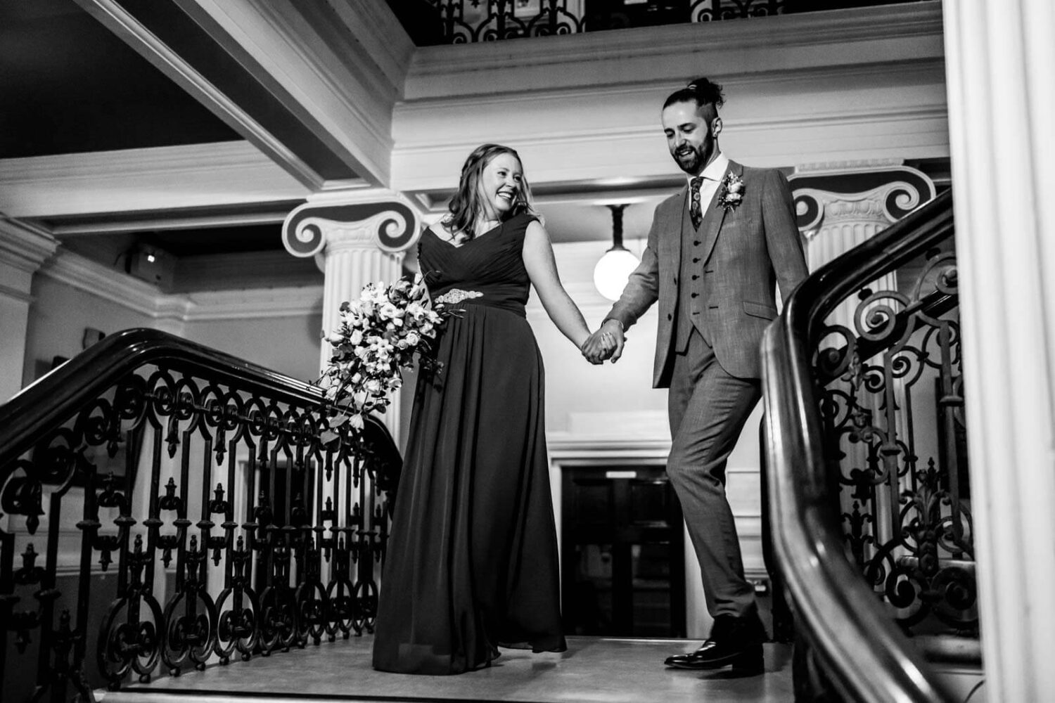 inside brighton town hall bride and groom walking down stairs