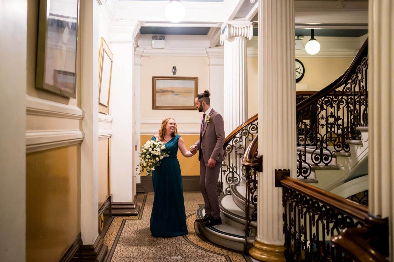 inside brighton town hall bride and groom walking down stairs