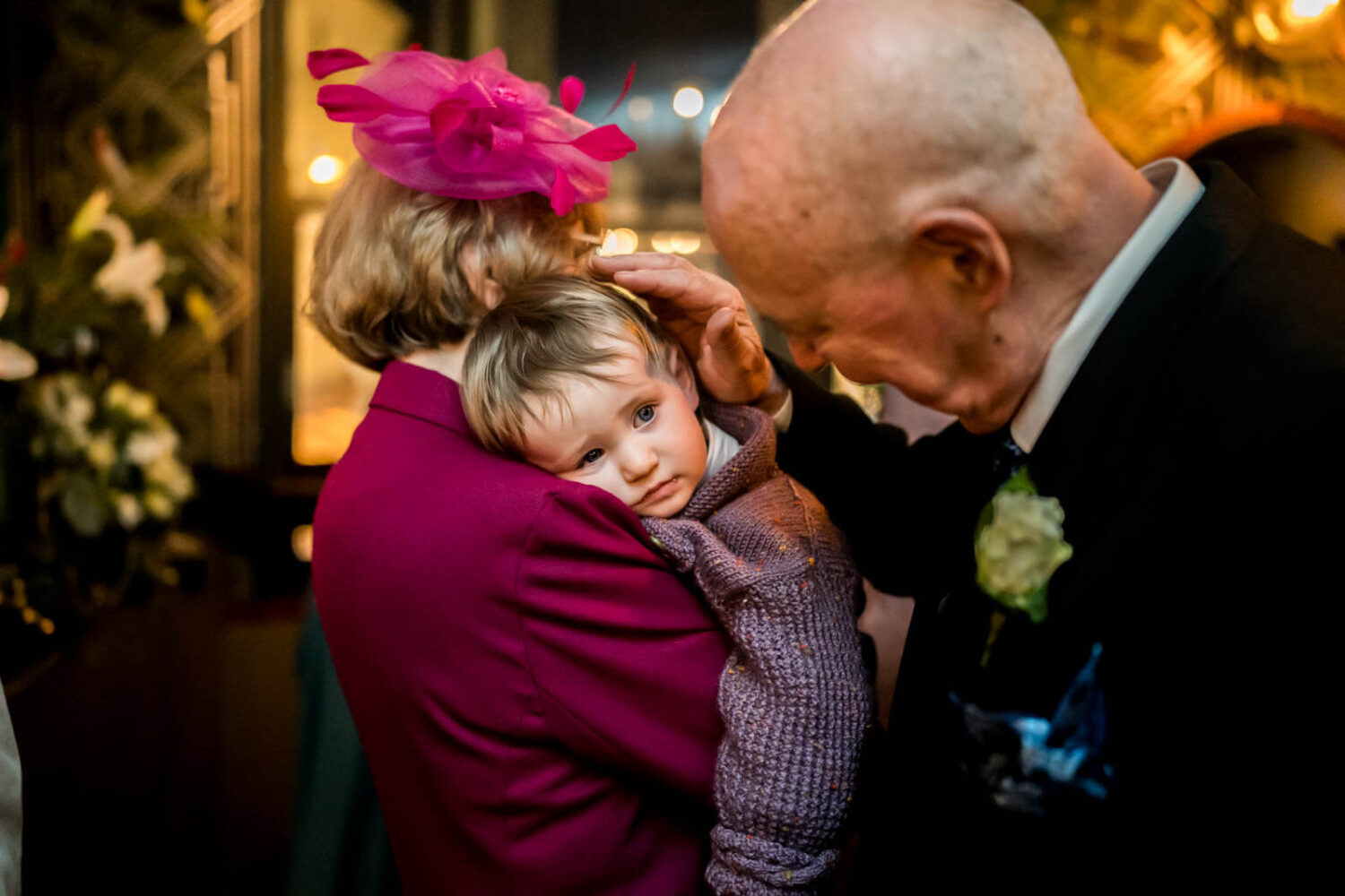 grandparents with grandson sleepy on shoudler
