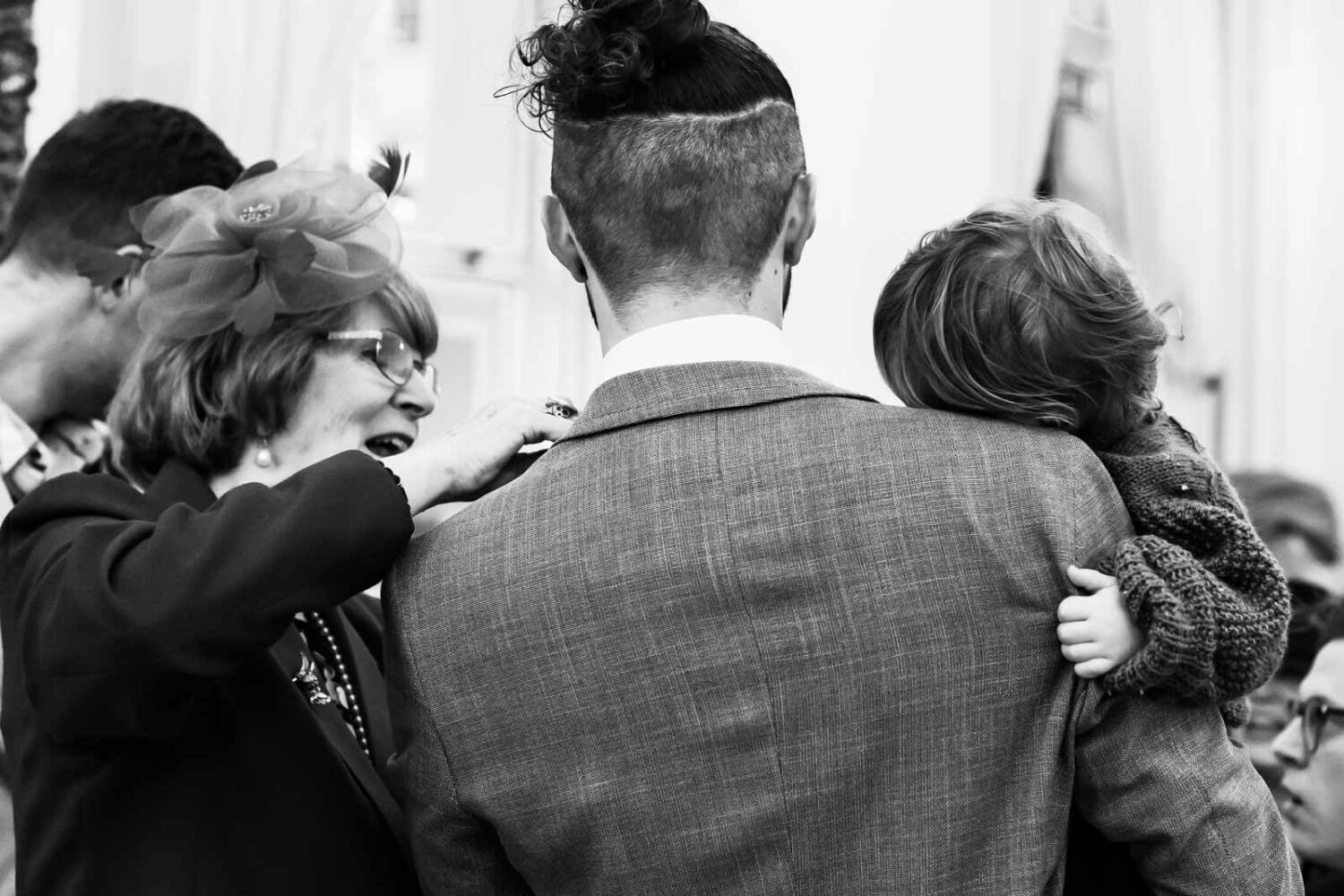 behind shot of groom with kid and mum