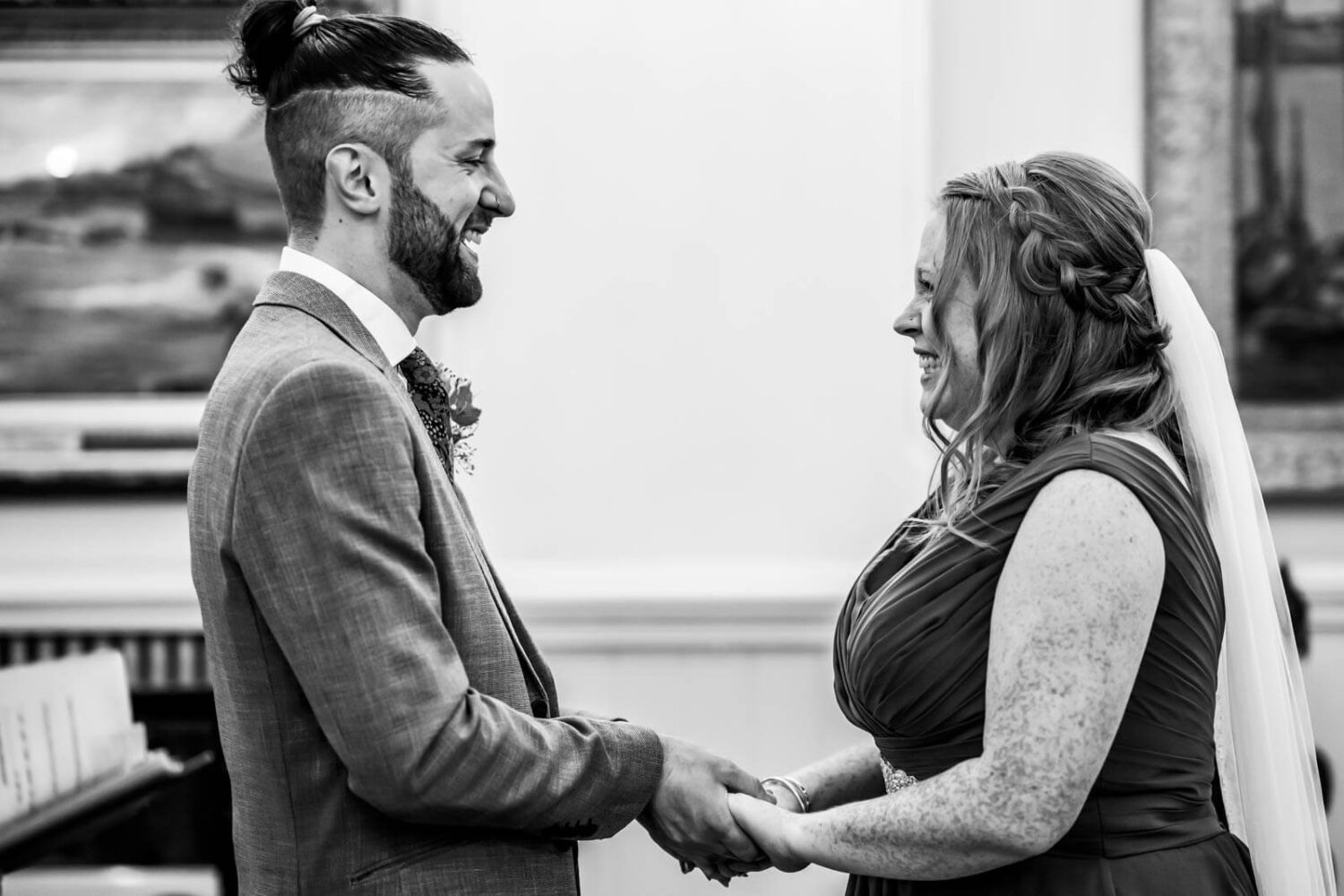 bride and groom holding hands looking at each other