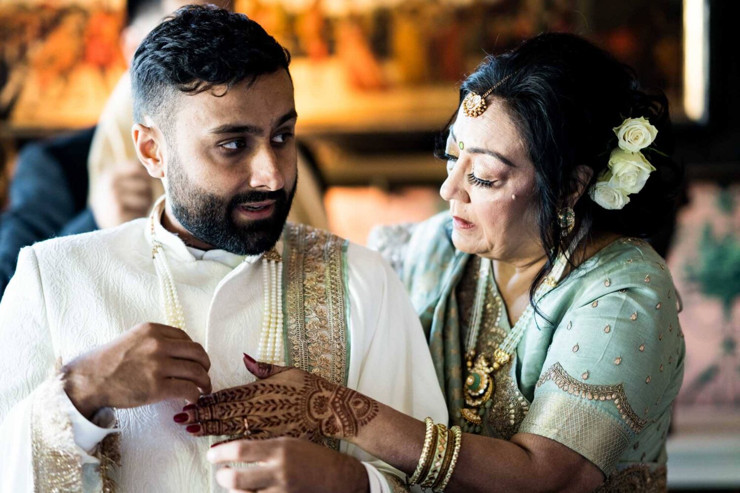 mother doing final touches on son's outfit