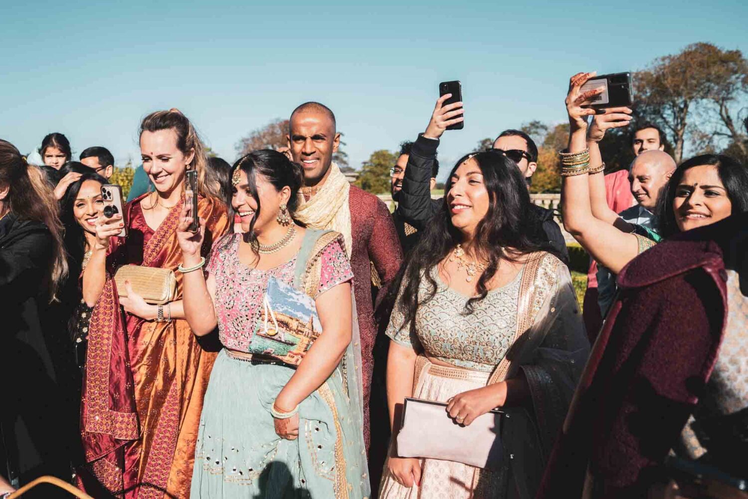 guests at firle place holding up phones waiting for groom