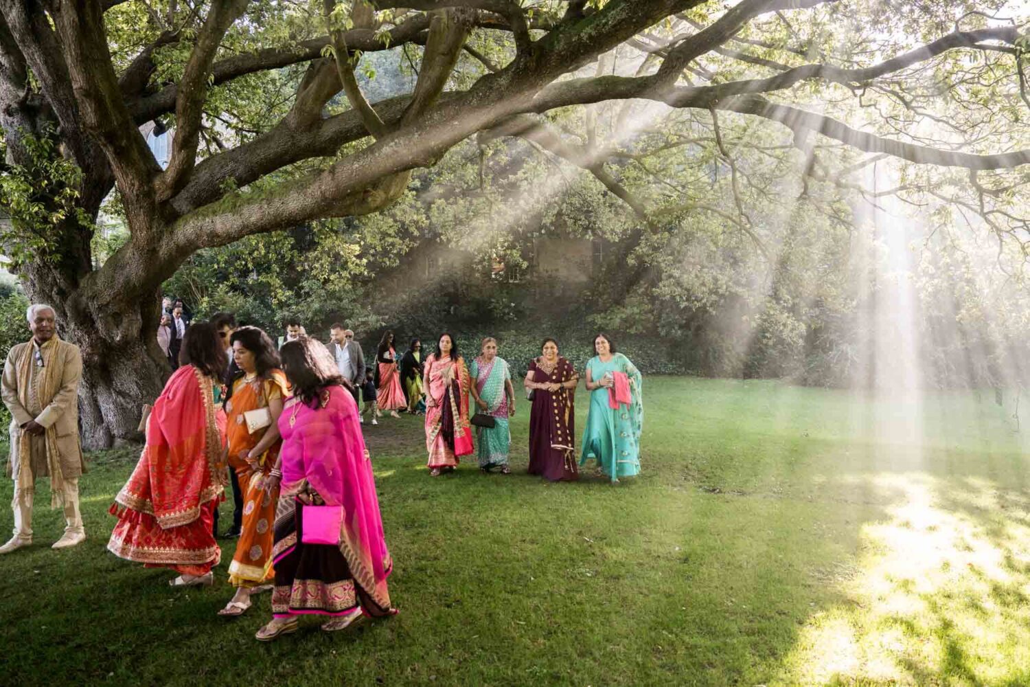 smokey shadows with guests walking through gardens at firle place
