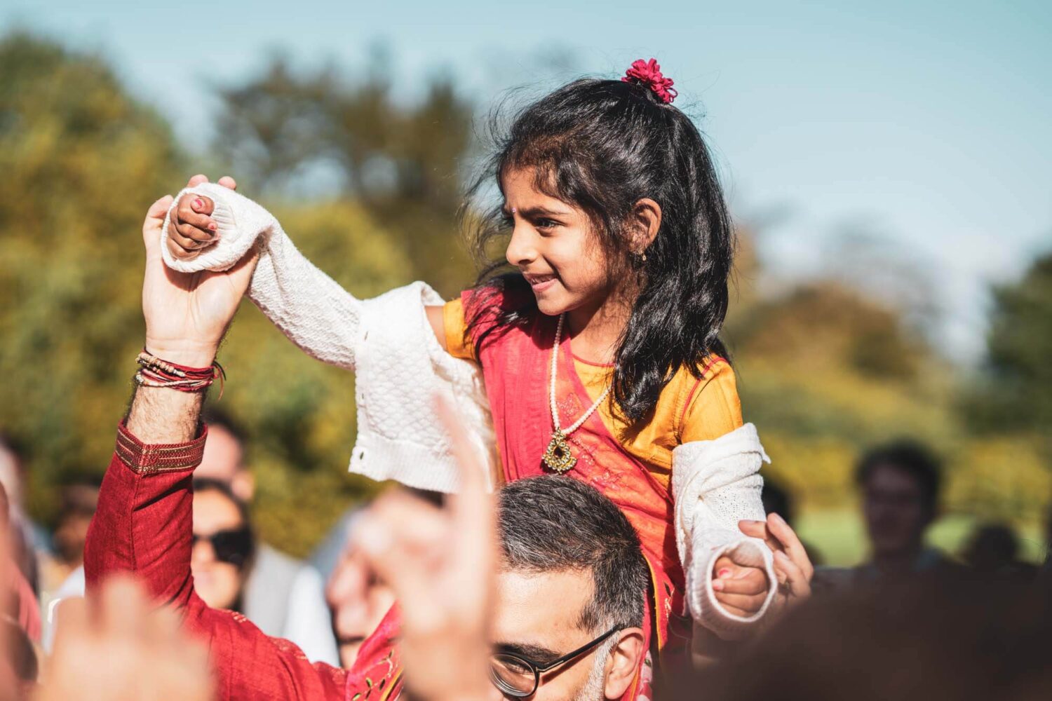 girl on dads shoulders at baraat at firle place