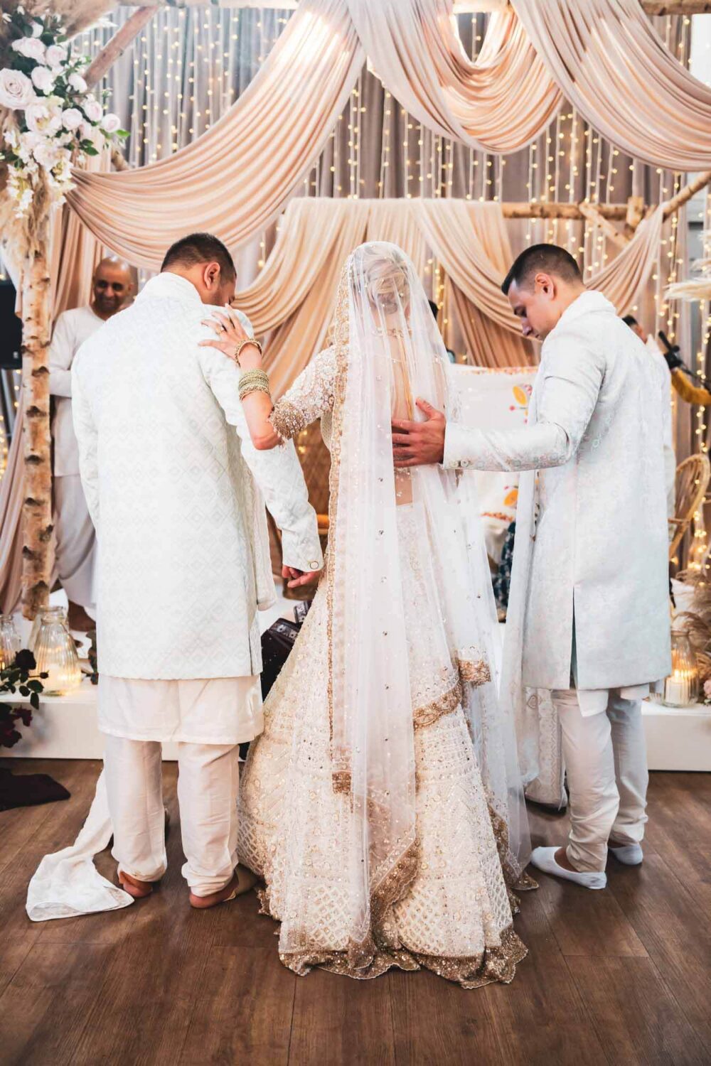 bride with arm around brother as she arrives at mandap at firle place