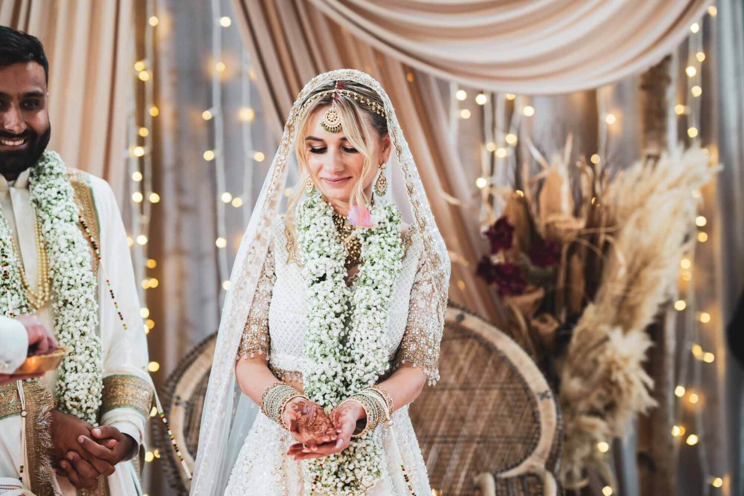 bride on mandap looking at hands at firle place