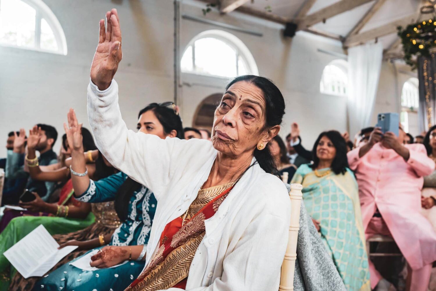 guest with hand up during hindu ceremony at firle place
