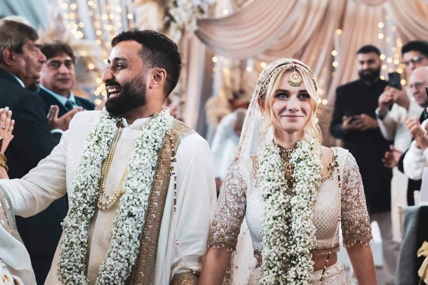 bride and groom walking down the aisle smiling