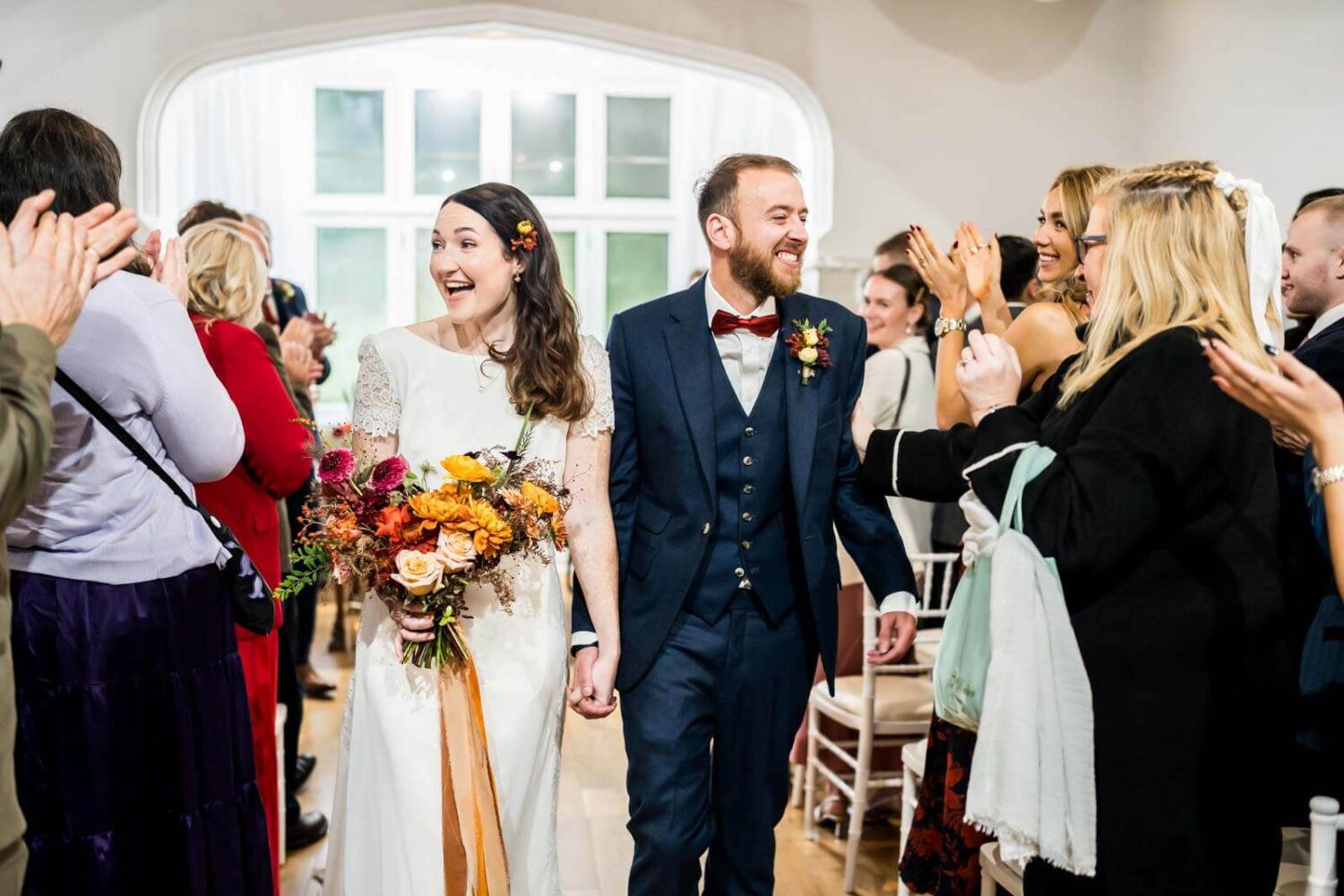 bride and groom walking away down the aisle smiling at highley manor