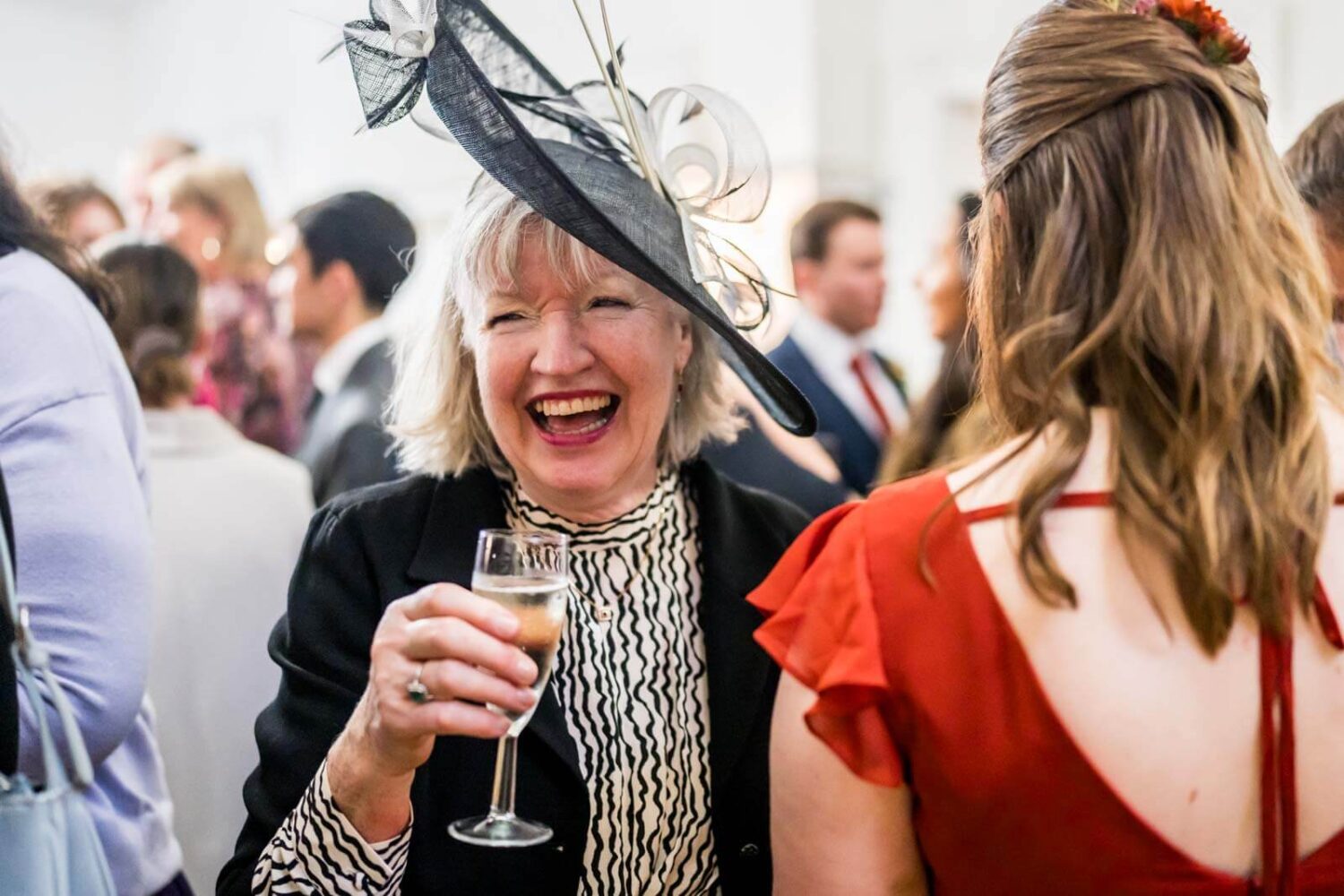 mother of the bride laughing with drink in hand at highley manor