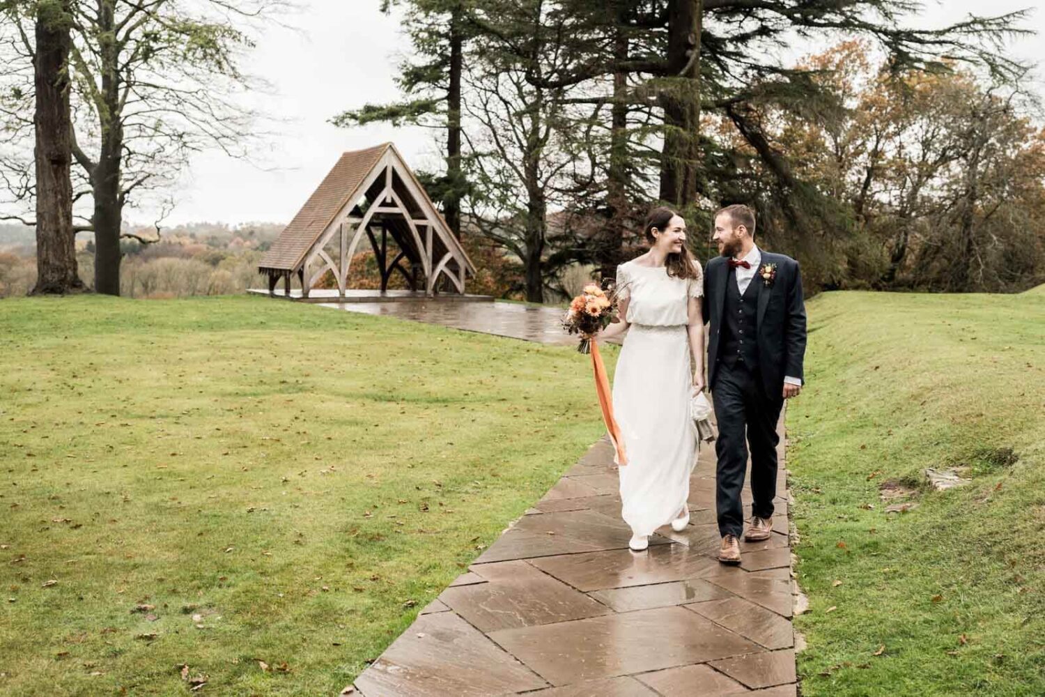 couple walking in gardens at highley manor looking at each other