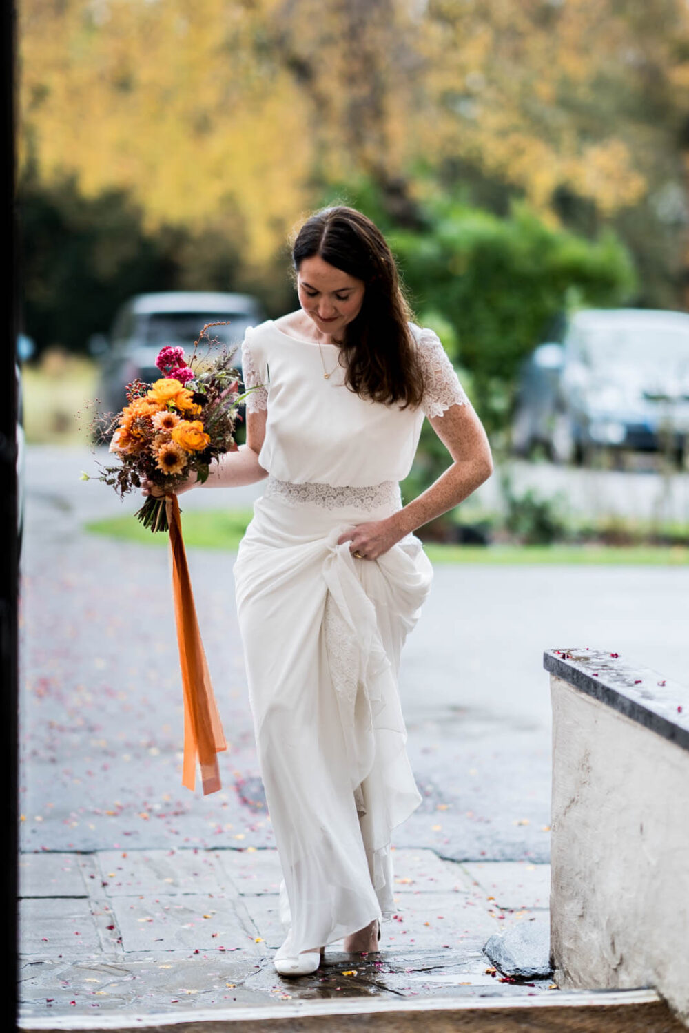 bride picking up her dress to walk through doorway at highley manor