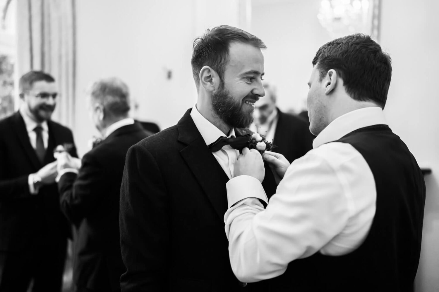 groom having his button hole put on by best man at highley manor