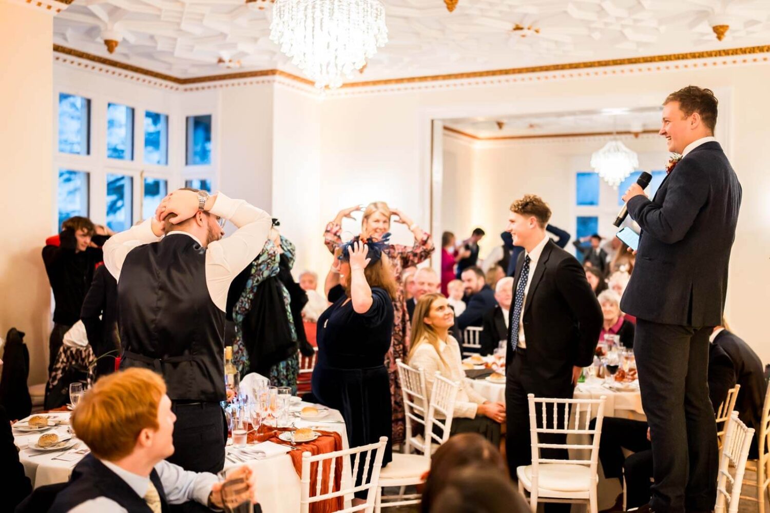 guests with hands on their heads during speech game