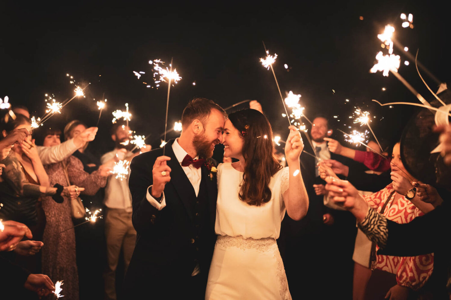 couple walking and kissing with sparklers at highley manor