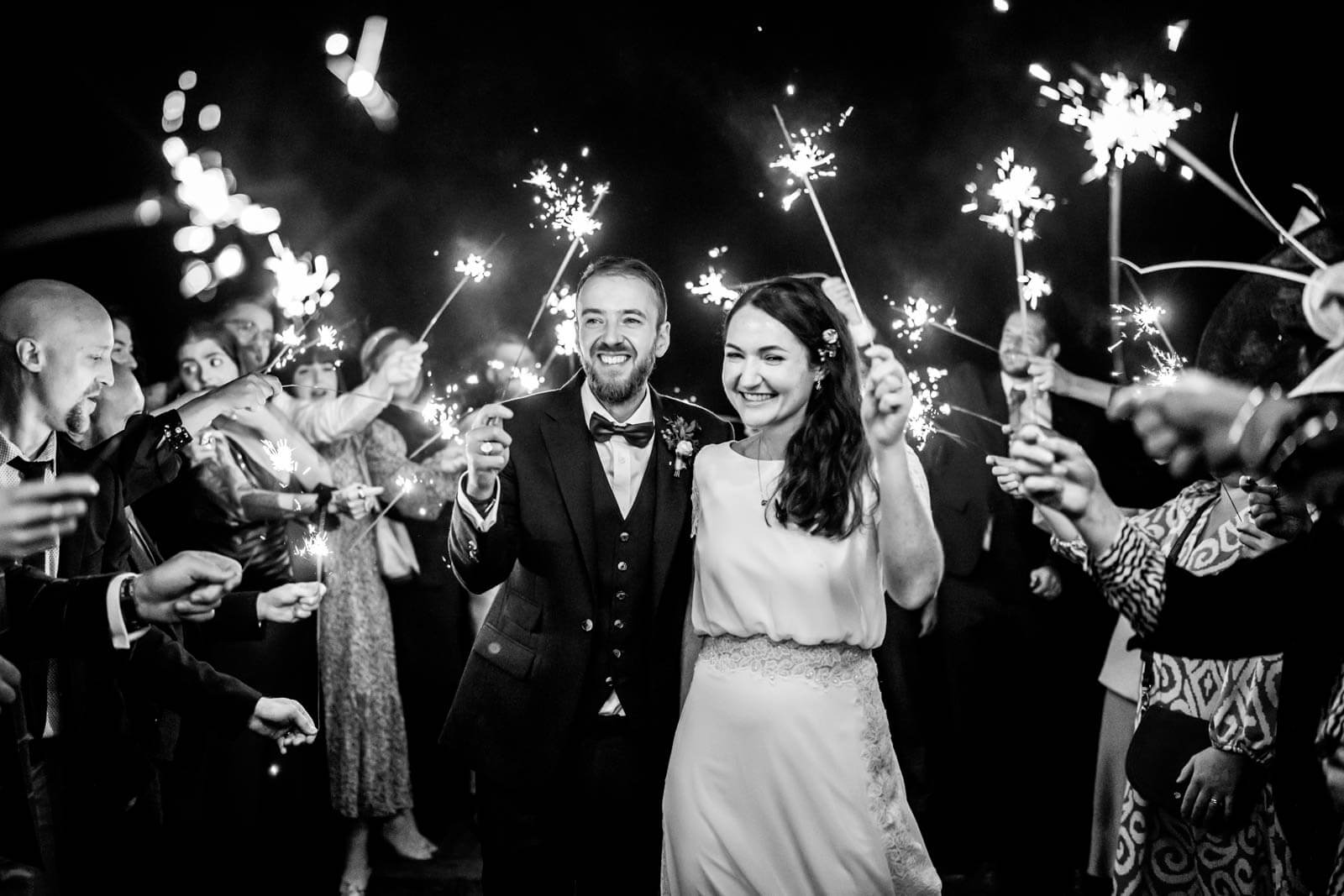 couple walking and laughing with sparklers at highley manor