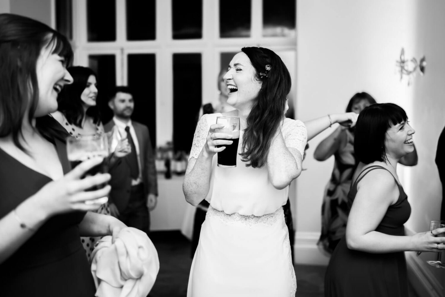 bride laughing with a glass of guinness